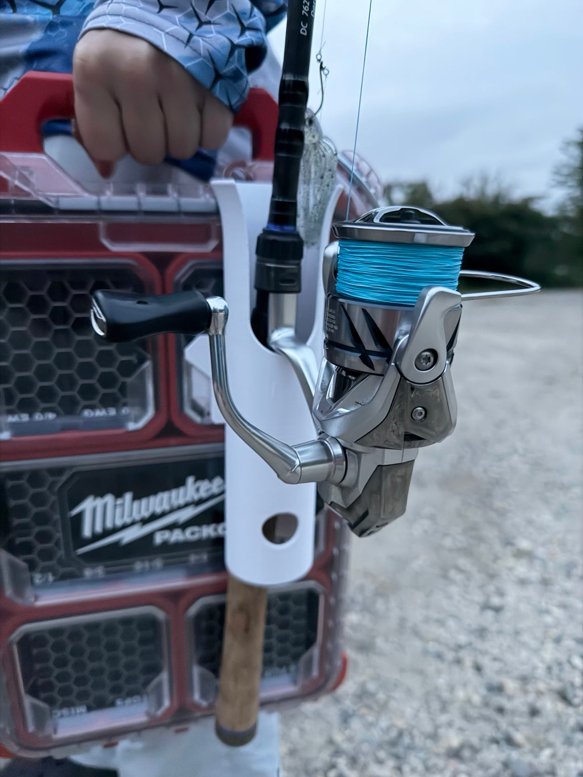 Close-up of PACKOUT-compatible fishing rod holder securing a spinning rod